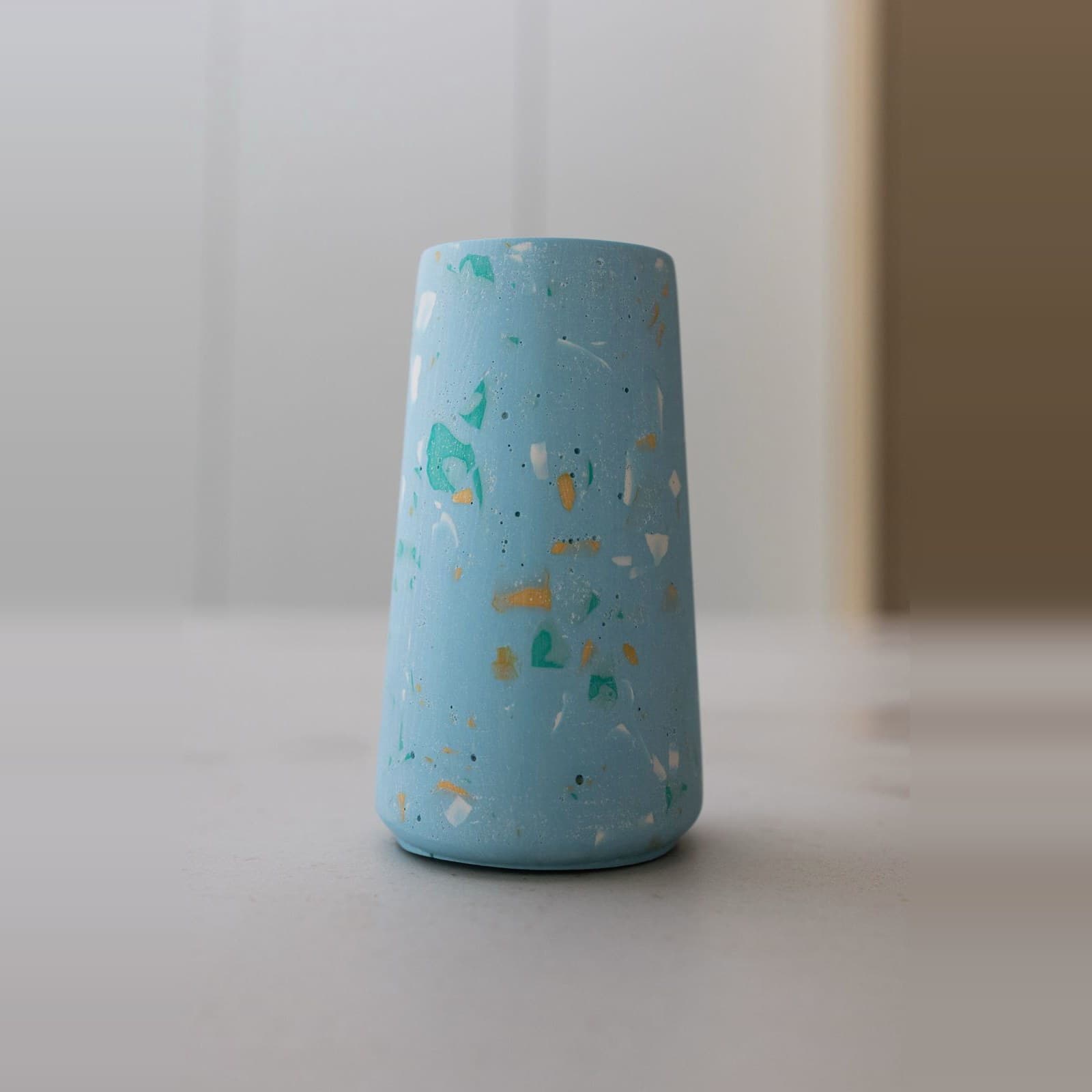 Taps lichtblauw terrazzo vaasje met turquoise, oker en witte spikkels