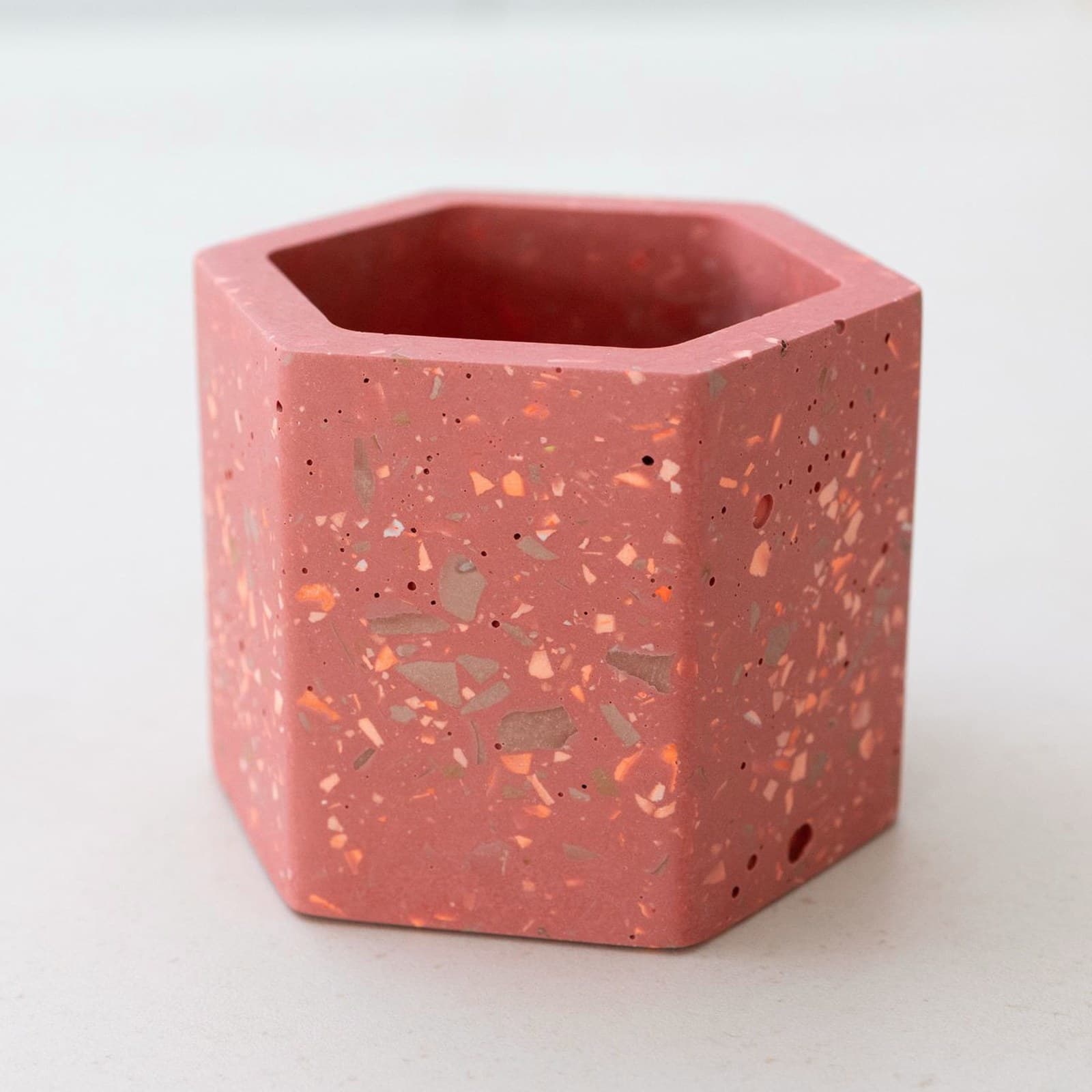 Zeshoekig koraalrood terrazzo bloempotje met perzik, oranje en grijze spikkels